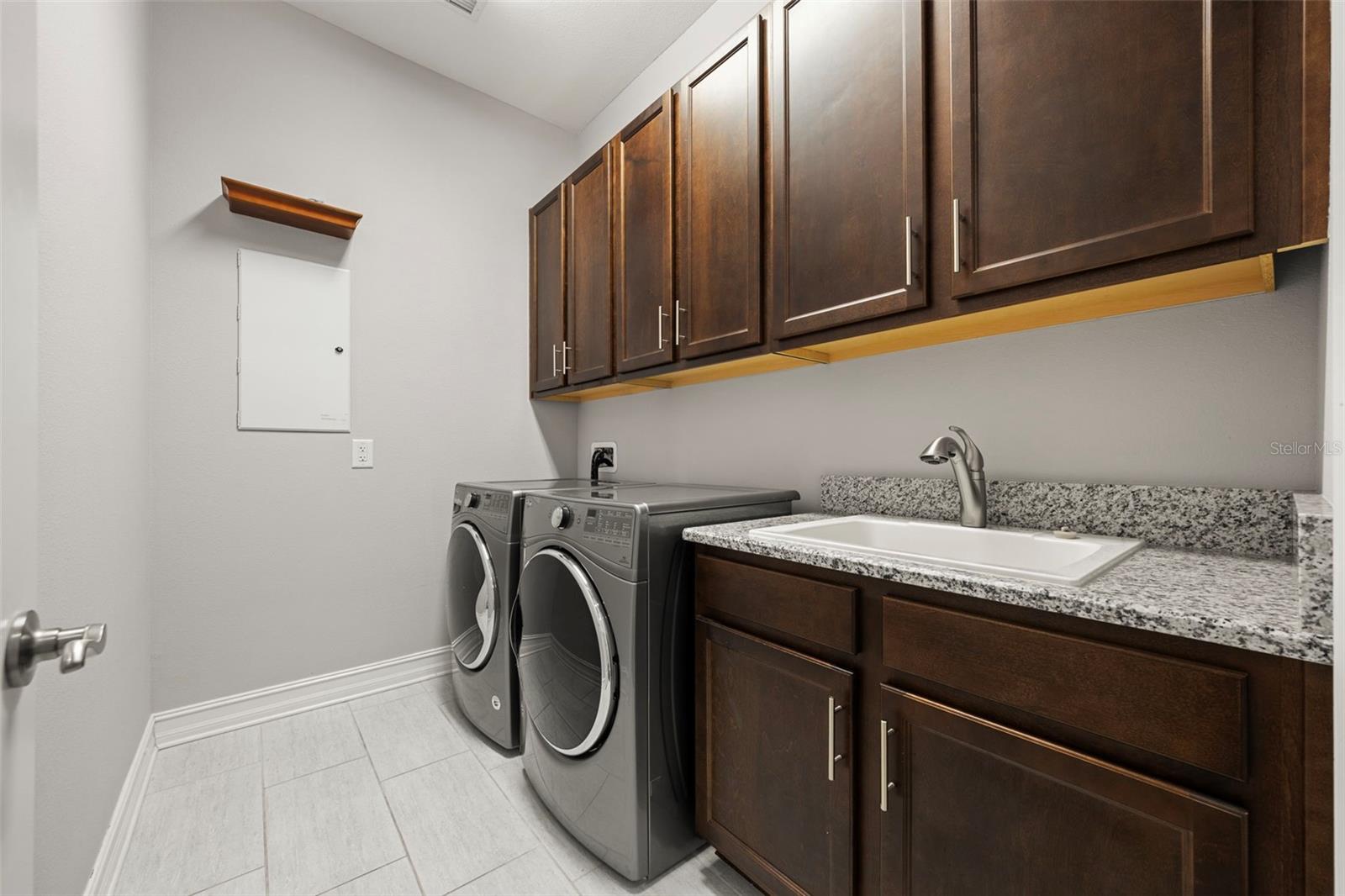 Laundry room with a sink & plenty of storage space