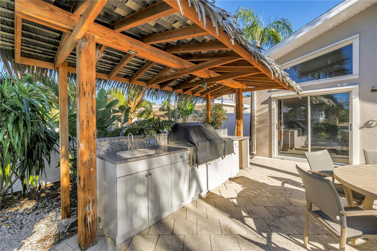 Outdoor Tiki hut style BBQ, sink with waterfront dining