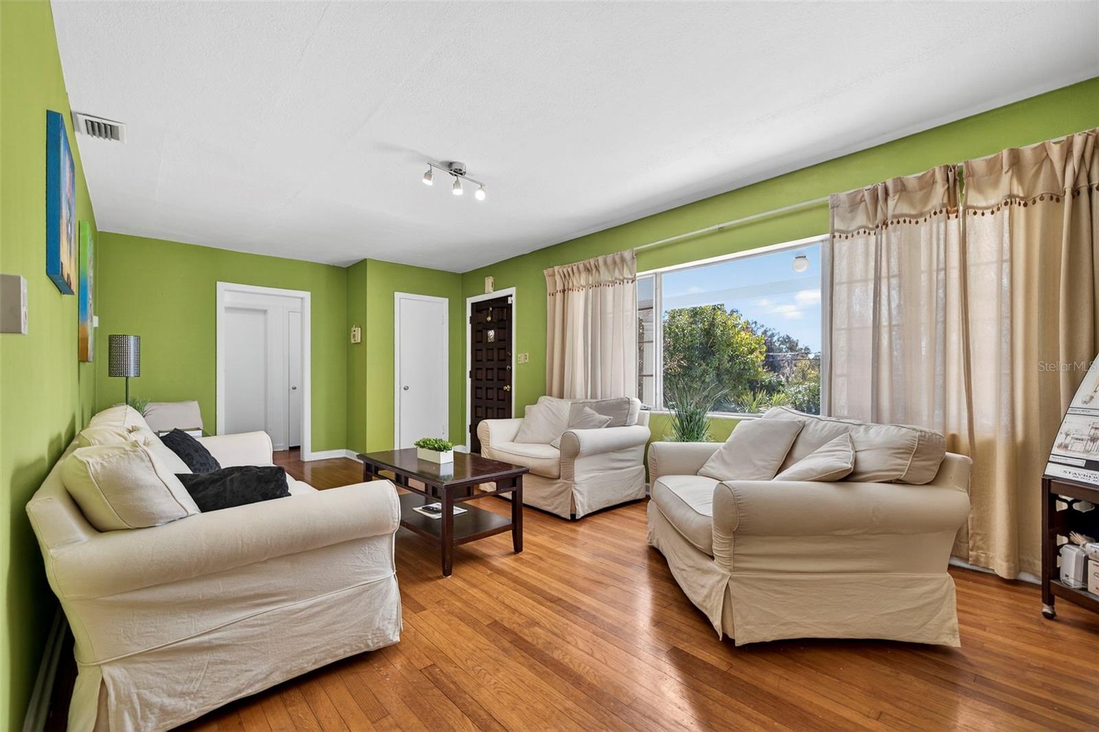 The spacious living room is filled with large windows that invite abundant natural light