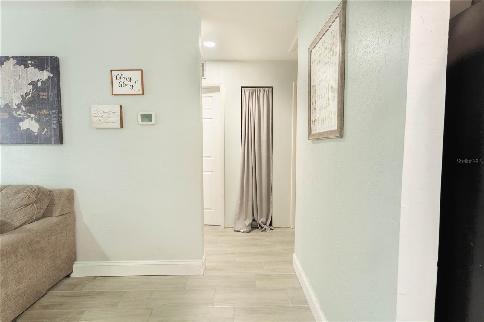 This hallway leads to several bedrooms and the largest primary suite.