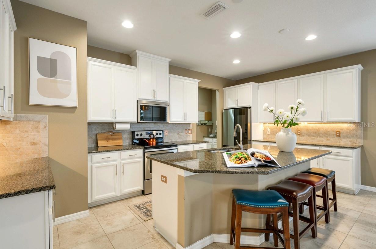 Spacious open kitchen with views of back oasis and pond.