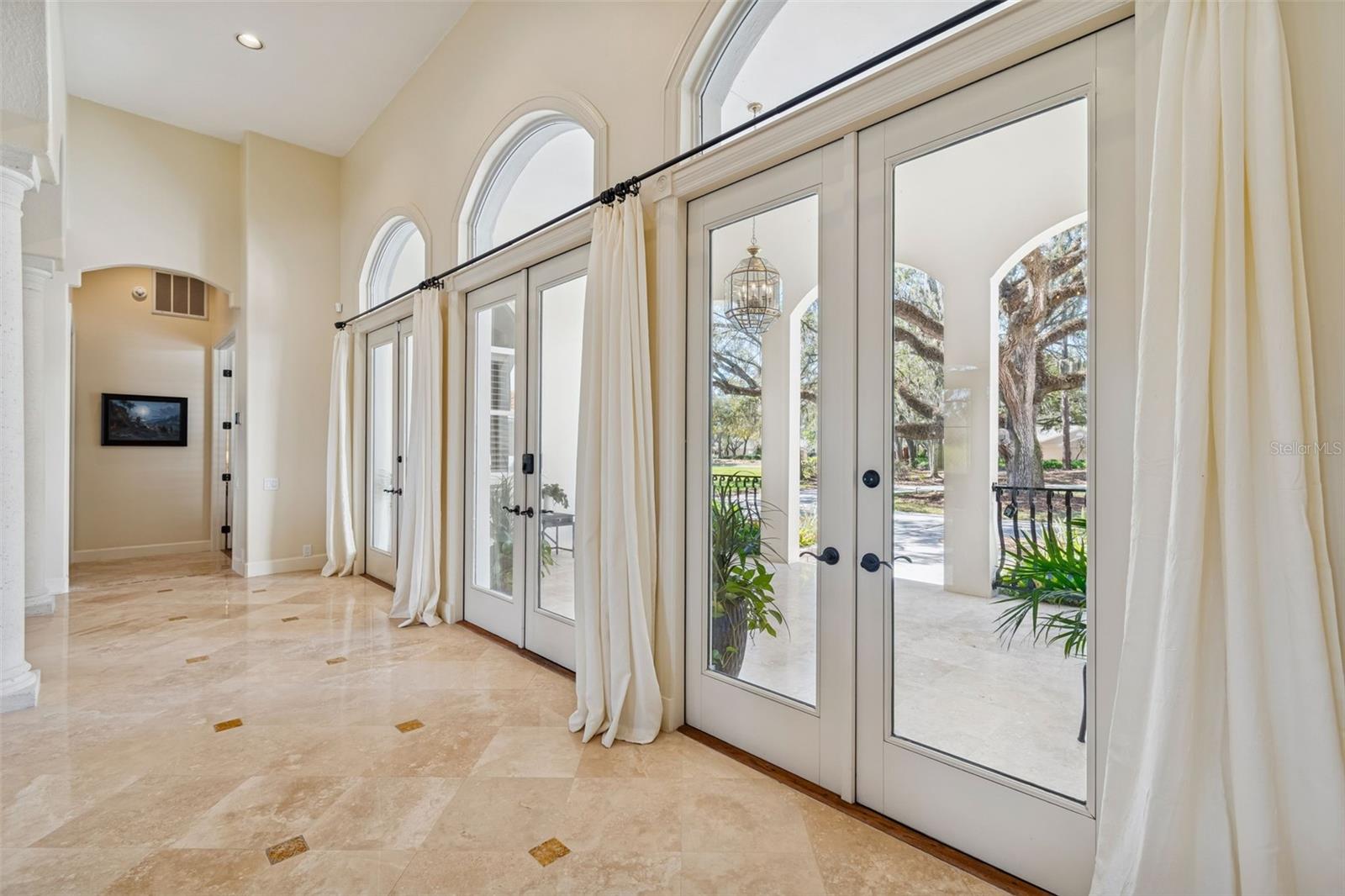 Travertine Entryway with 14' Ceilings with Columned Arches Leading Into Living Room Dining Room Area