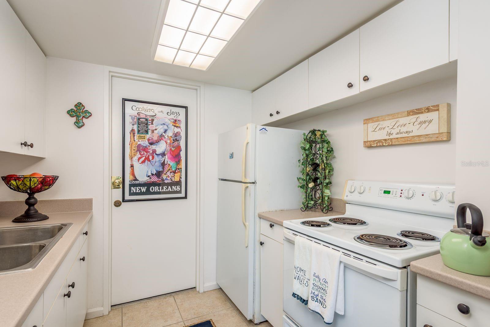A Galley Kitchen w Storage and its own door to the hallway.