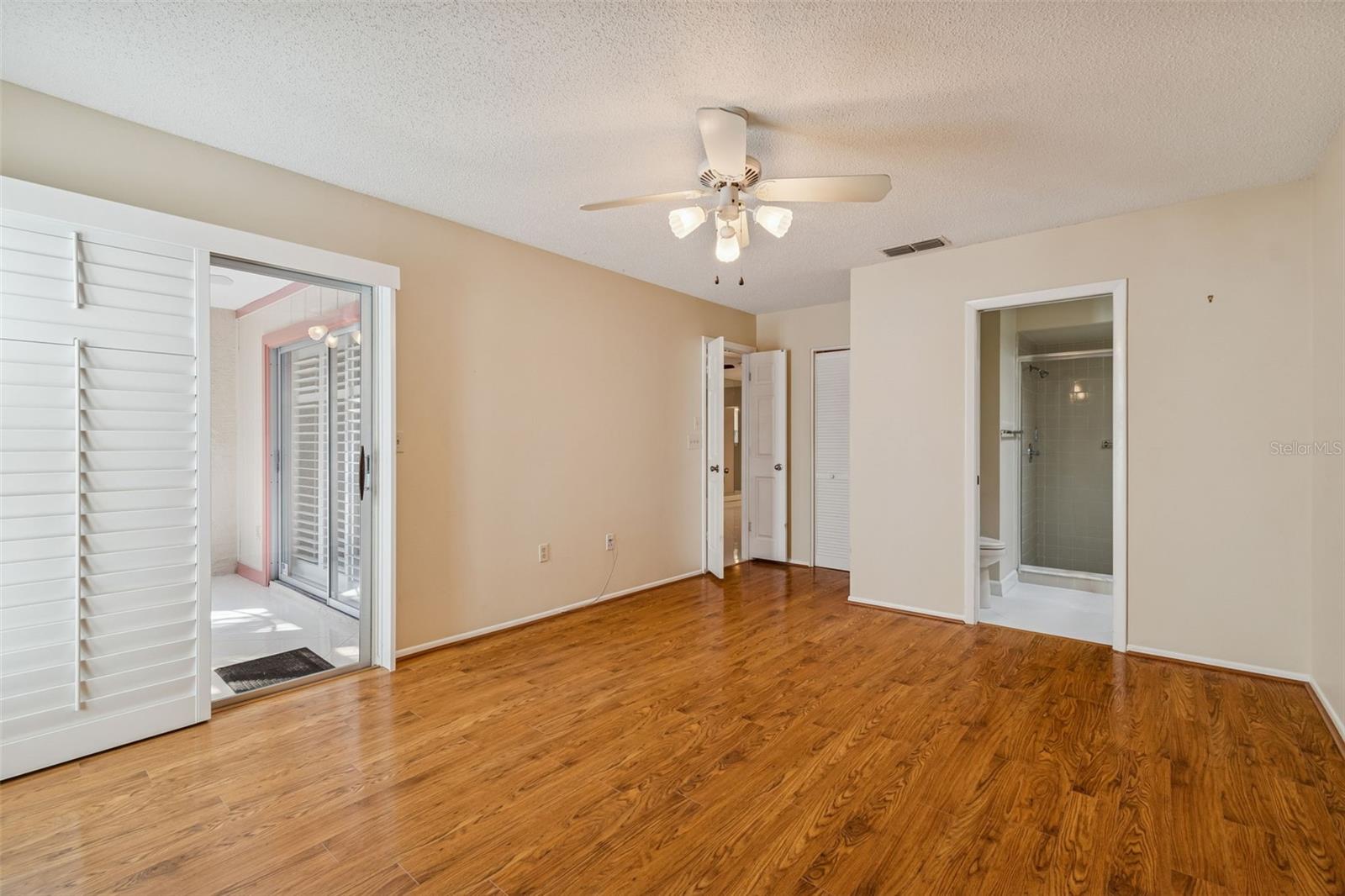 Primary bedroom with sliders leading to sunroom.