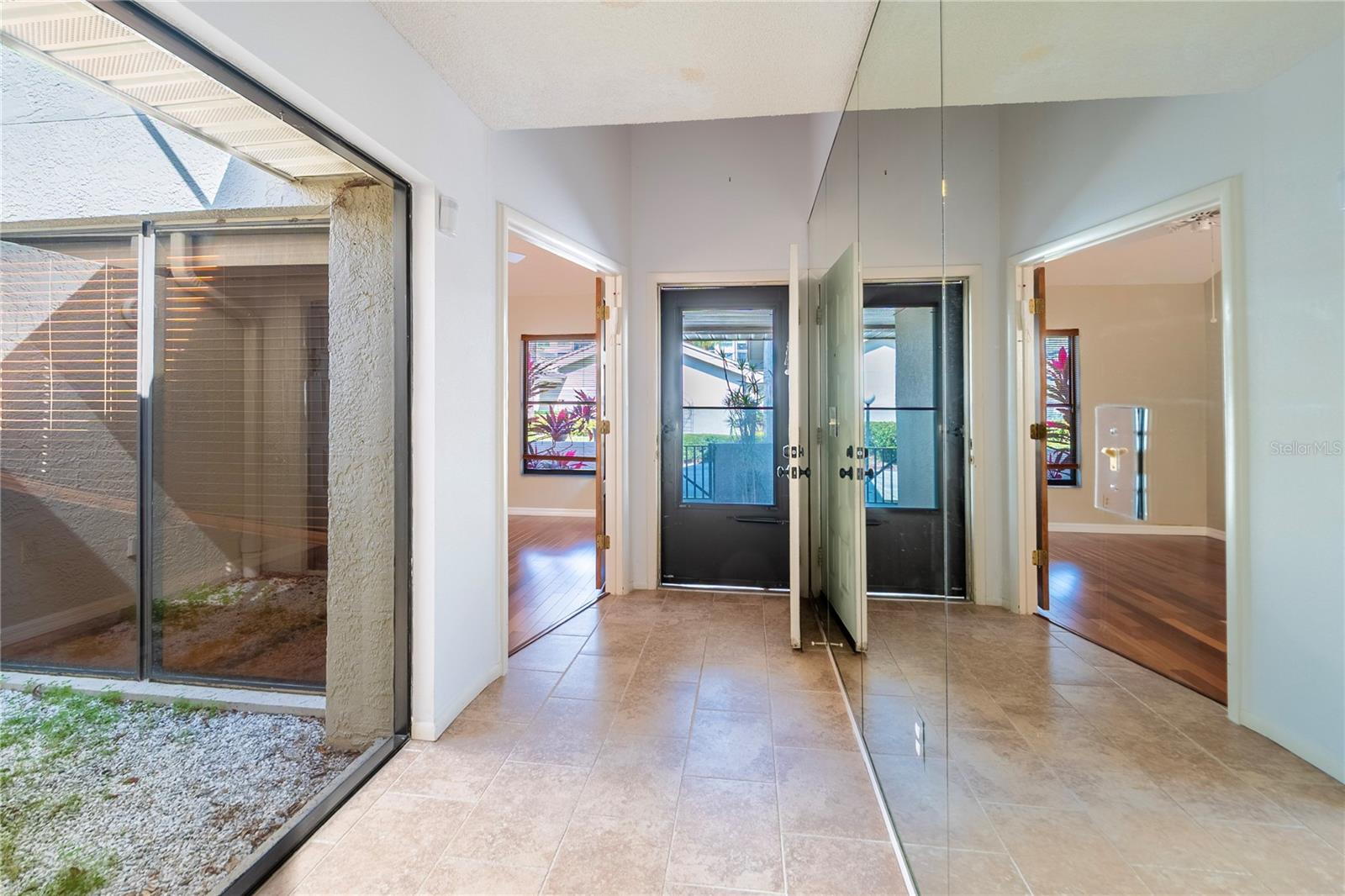 Entry door with flex/bonus room and glassed in atrium on left.