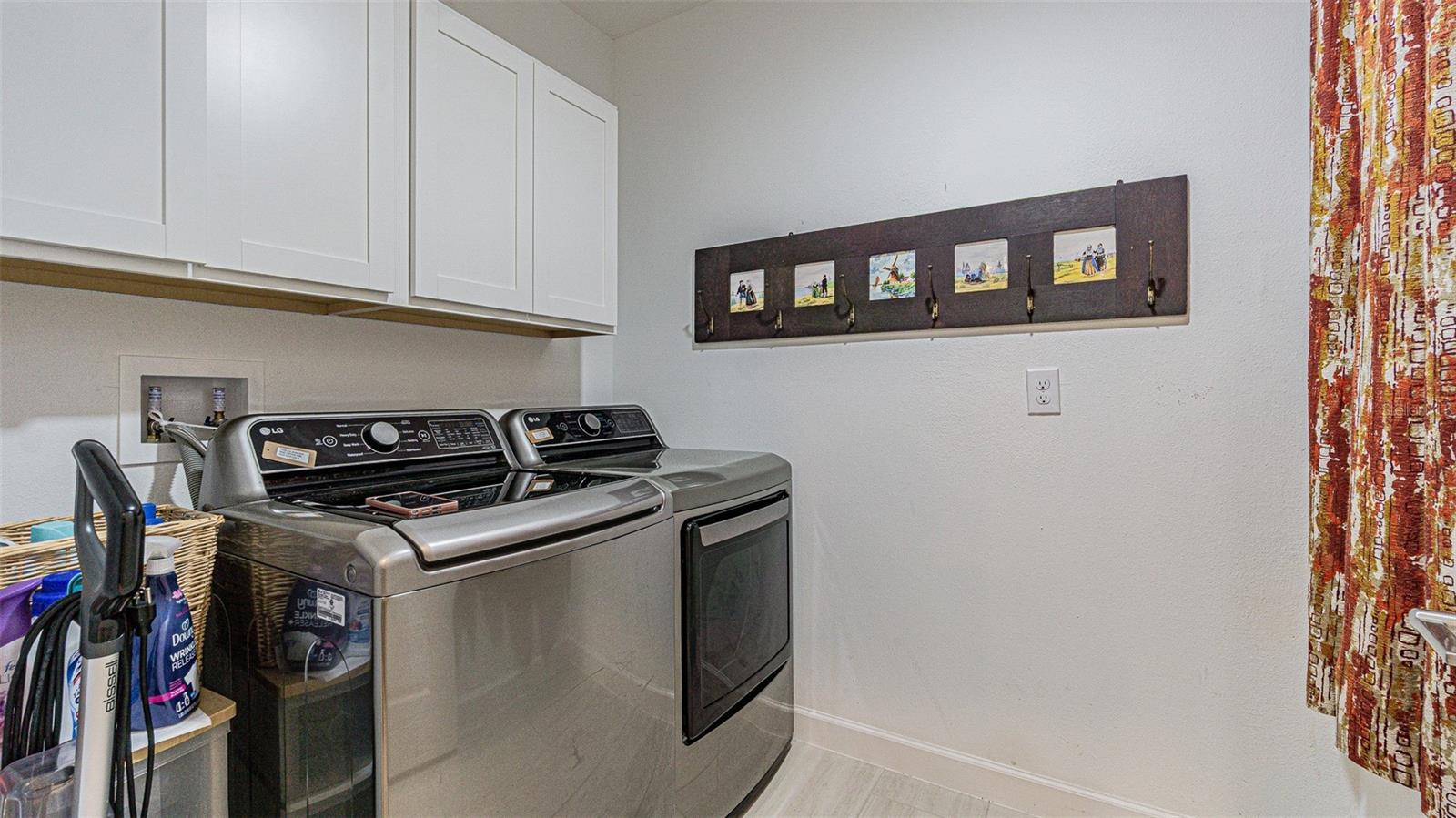 Interior laundry room with storage cabinets above washer/dryer