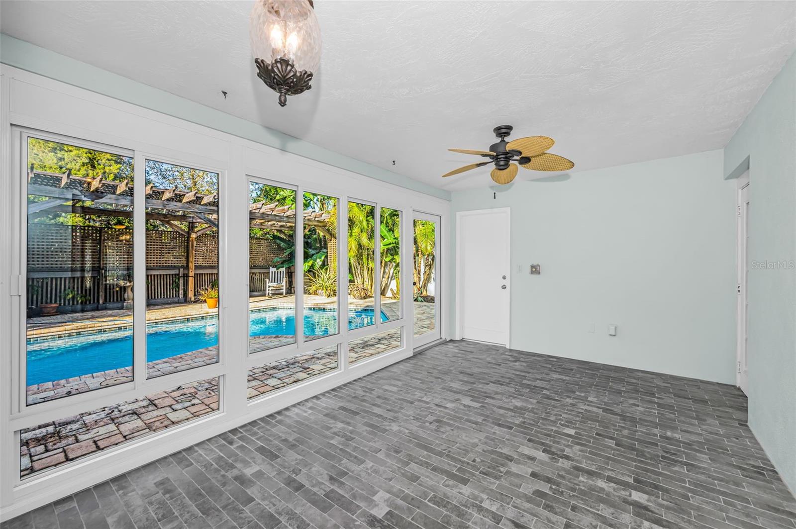 Enclosed lanai overlooks pool and portico.  Storage room entrance