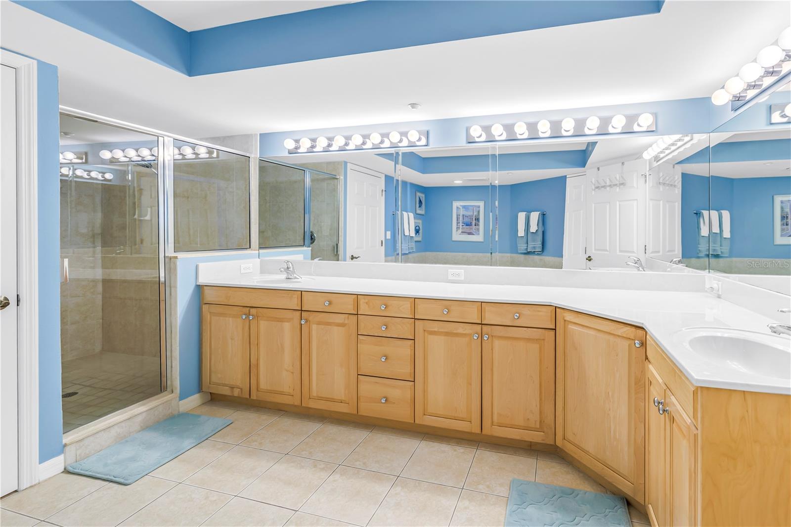 Primary bathroom linen closet, stand alone tub, water closet, standing shower, and large double vanity