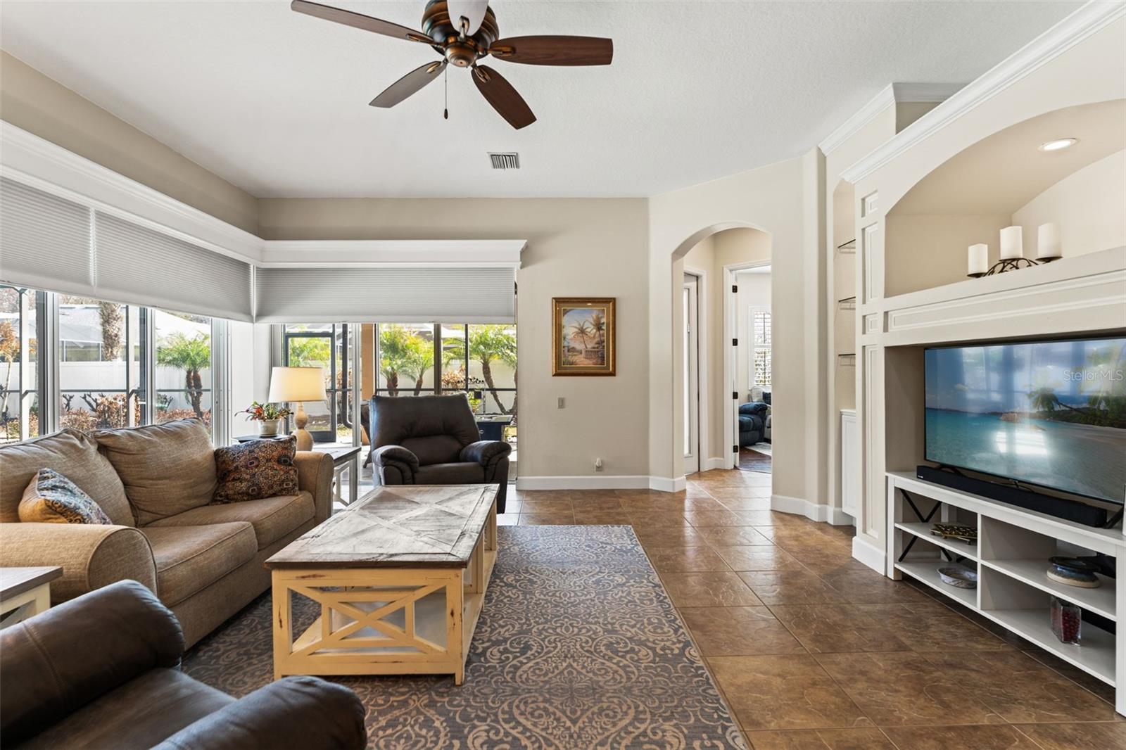 Spacious seating and neutral finishes create a relaxed atmosphere, enhanced by natural light and an open connection to the kitchen.