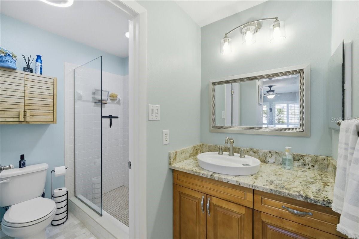 The primary bedroom enjoys beautiful water views, private sliding glass doors to the balcony, two closets with California Closet organizers, beautiful wood-look tile flooring, tastefully updated en-suite bathroom with a vanity room separate from the shower.