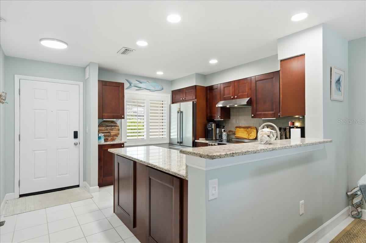 Stunning updated kitchen is well-equipped with stainless-steel appliances including a convection oven, rich cherry wood cabinets with soft closing cabinets and drawers, granite countertops, and beautiful, easy maintenance tile floors that flow into the main living areas.