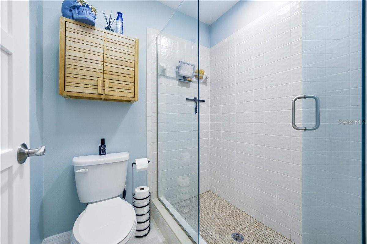 The primary bedroom enjoys beautiful water views, private sliding glass doors to the balcony, two closets with California Closet organizers, beautiful wood-look tile flooring, tastefully updated en-suite bathroom with a vanity room separate from the shower.
