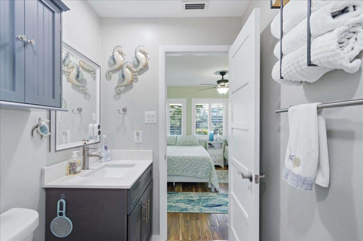 Second bedroom at the front of the unit with its own tastefully updated en-suite bathroom, three windows, beautiful wood-look tile flooring, decorative ceiling fan and California Closet.