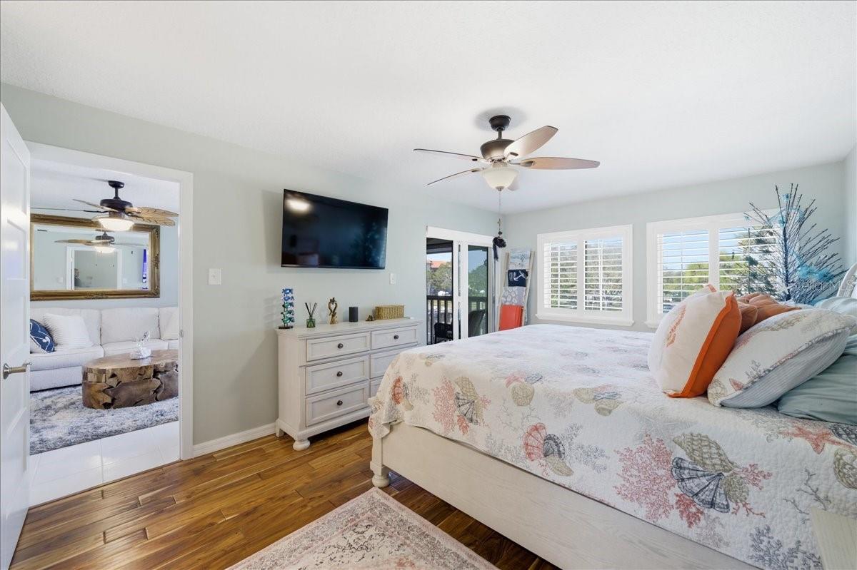 The primary bedroom enjoys beautiful water views, private sliding glass doors to the balcony, two closets with California Closet organizers, beautiful wood-look tile flooring, tastefully updated en-suite bathroom with a vanity room separate from the shower.