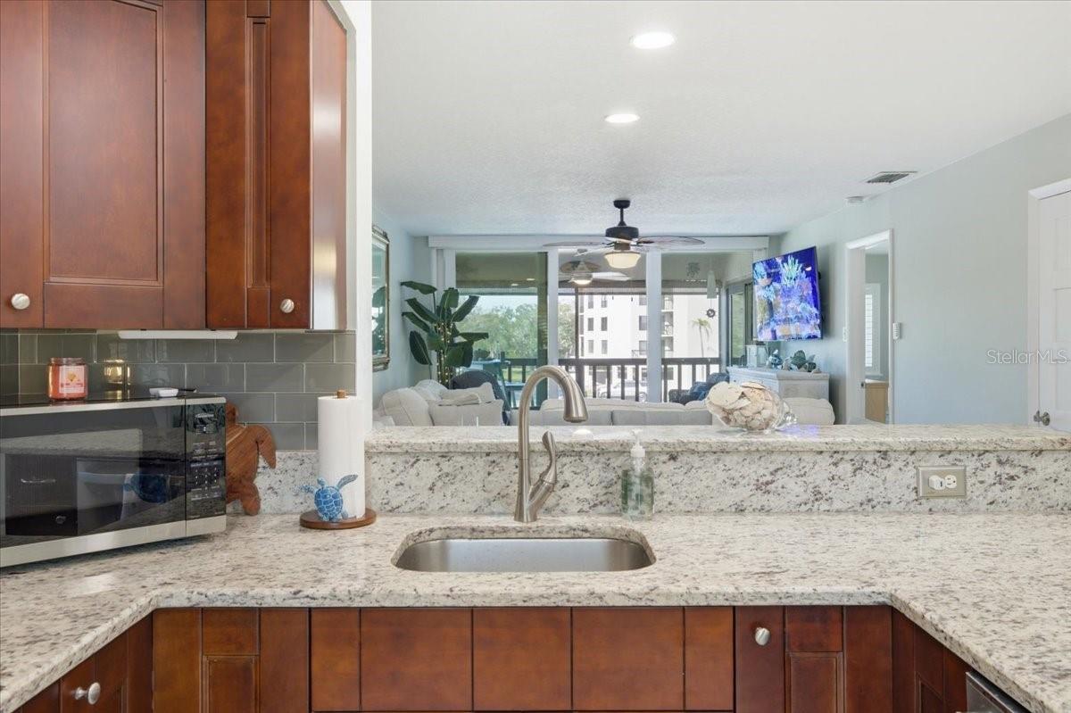 This stunning kitchen offers connection to dining and living areas with views and natural lighting from wall of sliders out to balcony