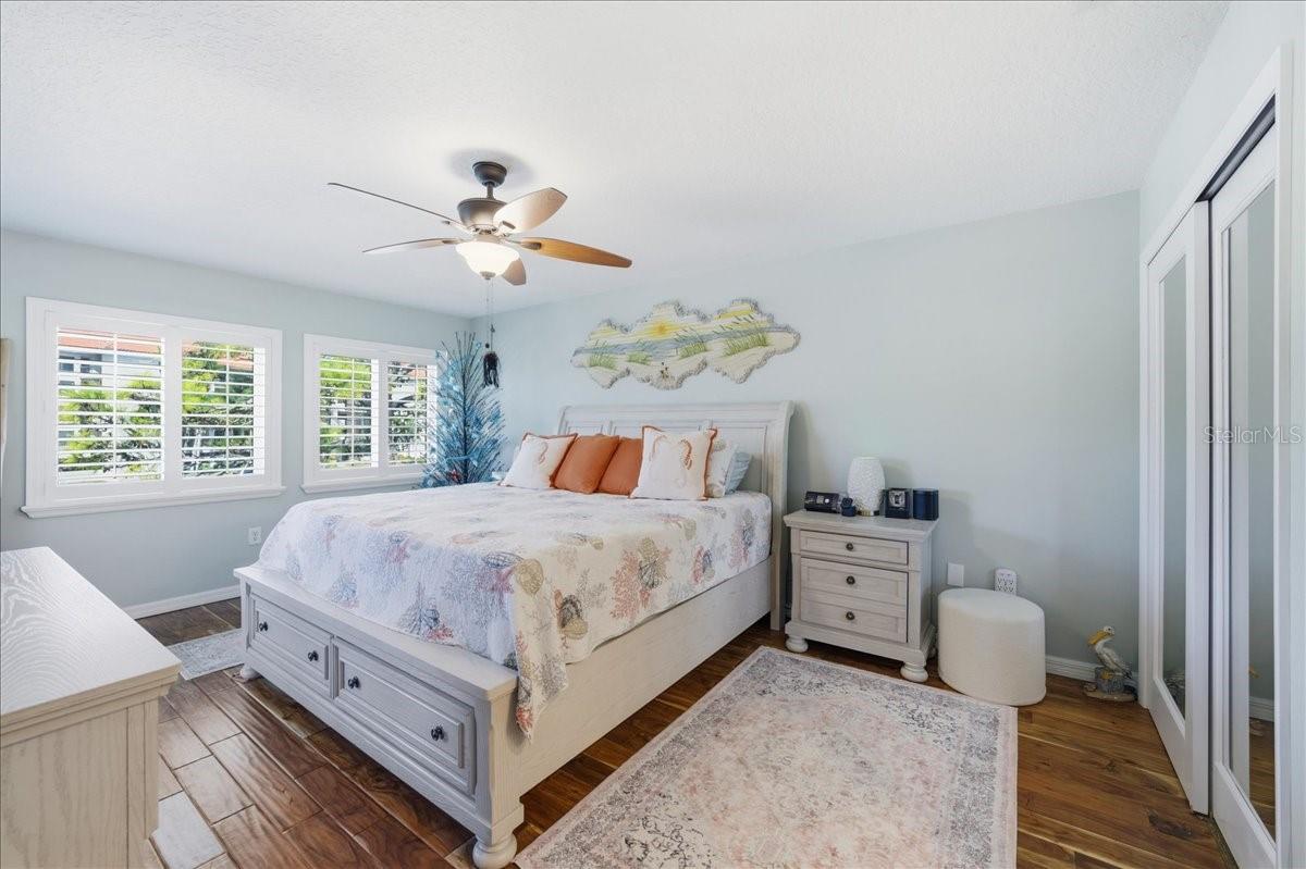 The primary bedroom enjoys beautiful water views, private sliding glass doors to the balcony, two closets with California Closet organizers, beautiful wood-look tile flooring, tastefully updated en-suite bathroom with a vanity room separate from the shower.