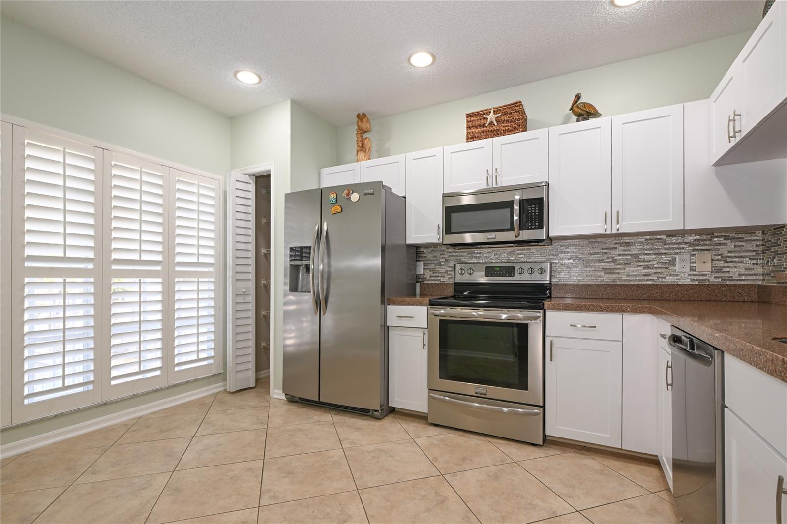 Enjoy every-day luxury with granite countertops and dazzling refaced cabinets in kitchen