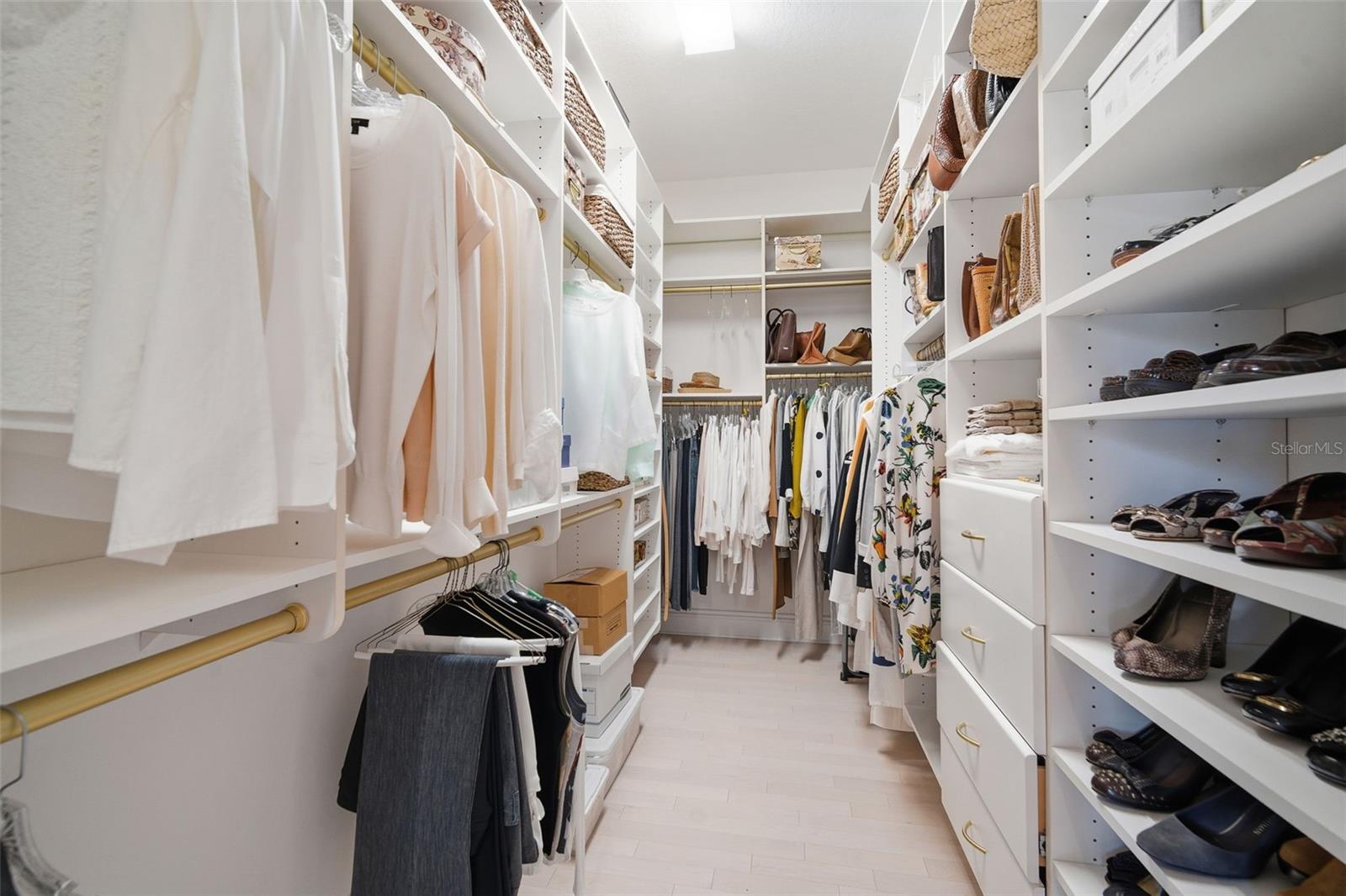 Spacious walk-in with custom cabinets and storage. Primary bedroom.