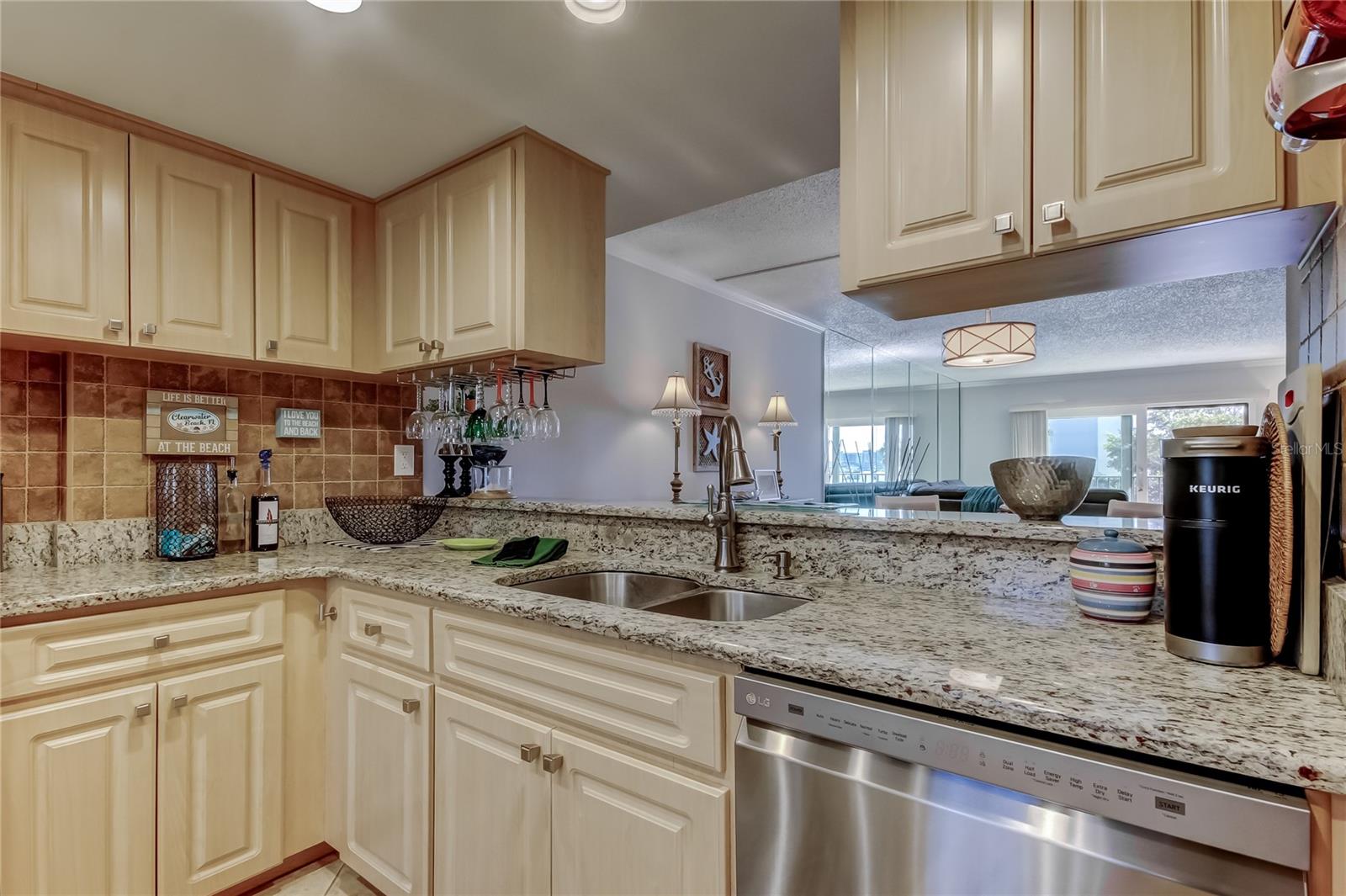 Kitchen has a dishwasher, granite countertops, and plenty of cabinets.