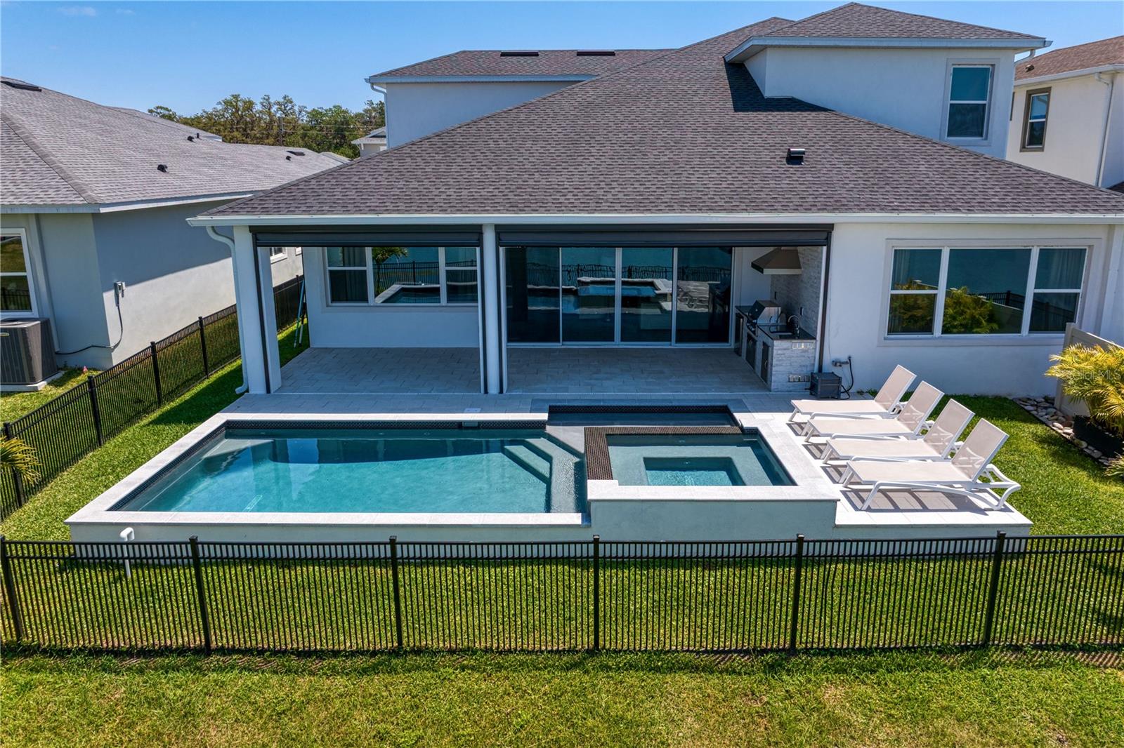 Resort-style outdoor space with pool, spa, and pond views.