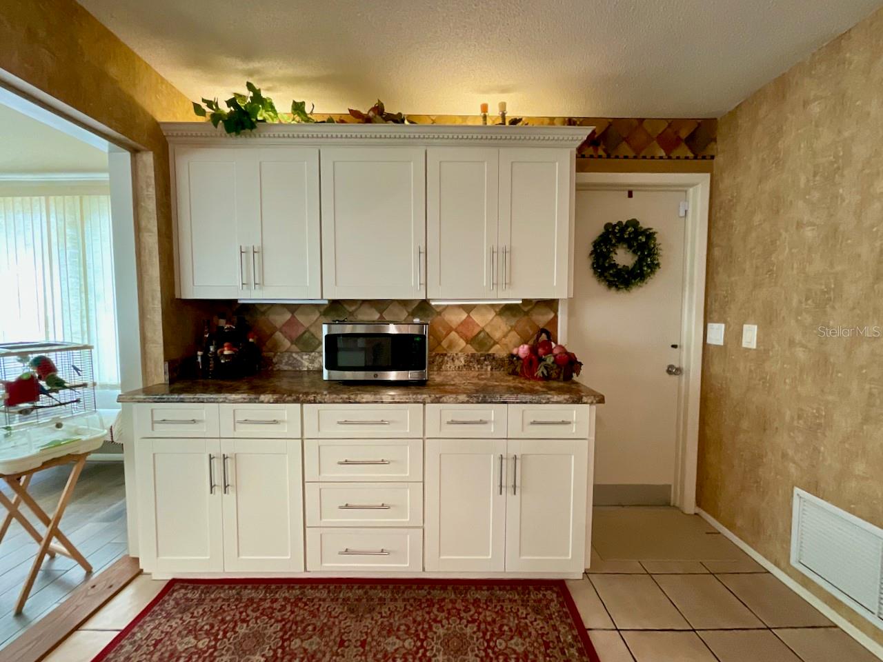 11-Kitchen microwave and extra cabinets with door to garage laundry area
