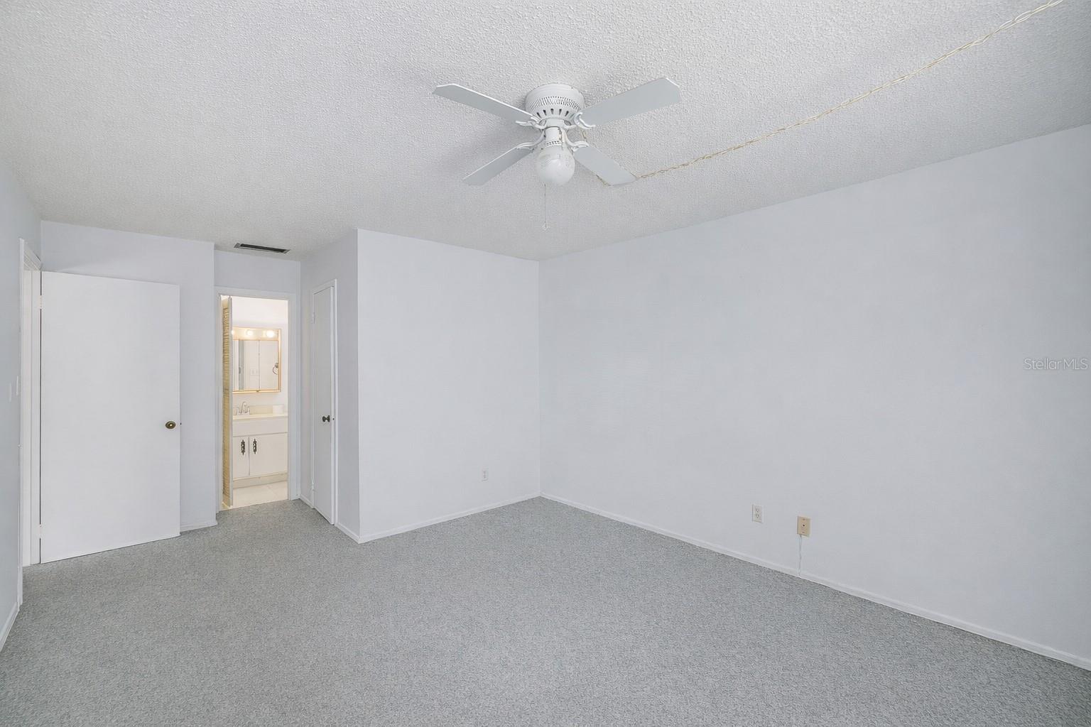 Primary bedroom with a full bath and walk in closet