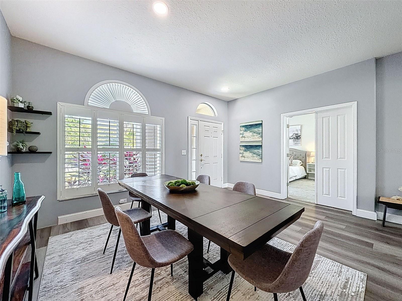 Formal dining room with beautiful plantation shutters.  Front guest bedroom/office on the right.