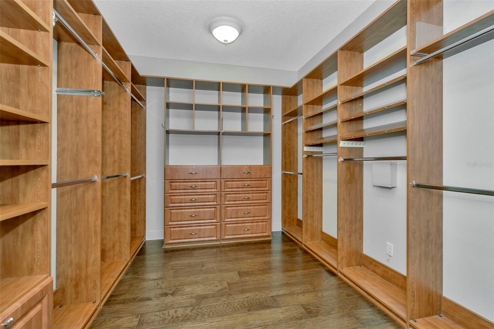 Gorgeous and massive walk-in closet in primary bedroom.