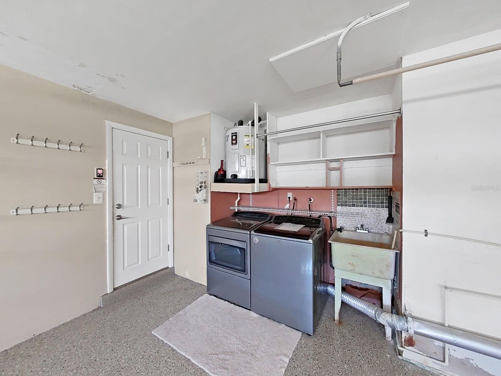 Garage Laundry area includes washer, dryer, utility sink & open shelving- all the utility you need in one convenient space!