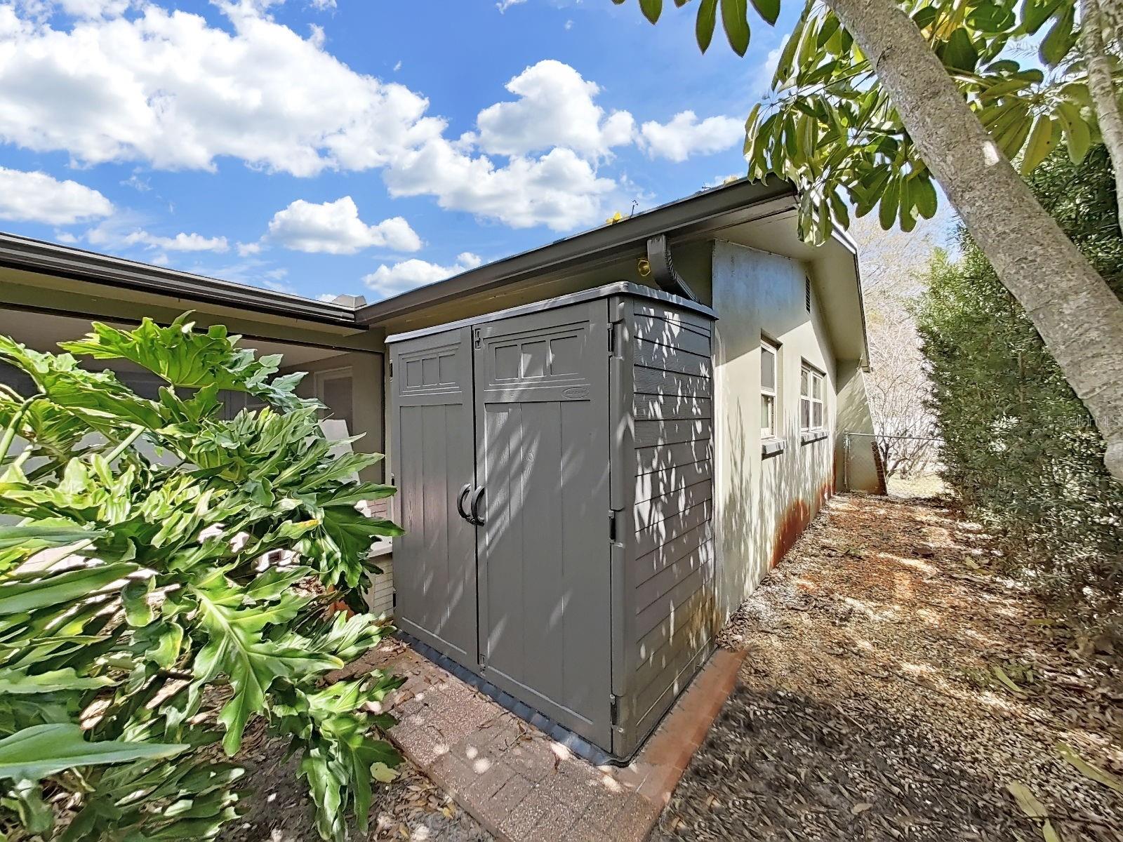 Convenient Suncast outdoor storage shed, included & tucked in the backyard, provides extra space for tools, lawn equipment, toys, or hobby gear amid mature shade trees.
