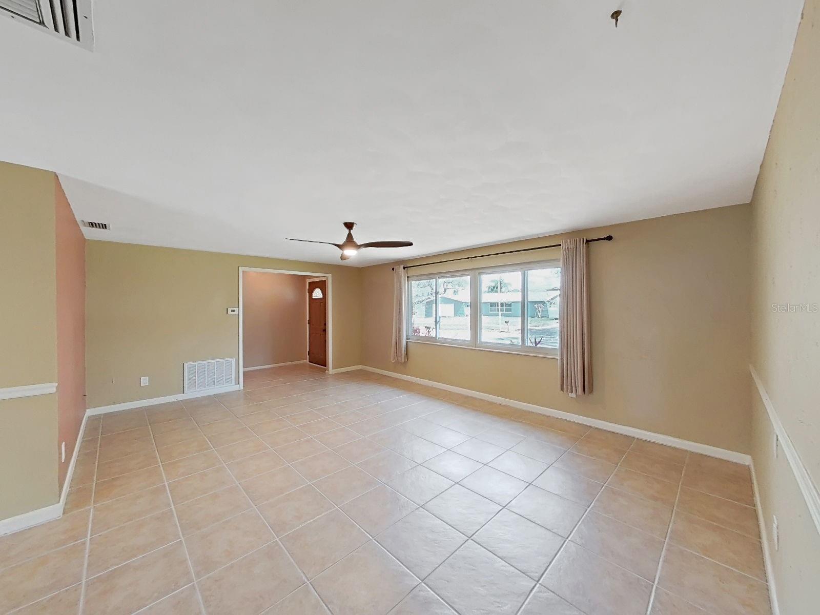 Expansive living room offers beautiful tile floors, ceiling fan, and bright natural light, with an open flow to adjoining rooms!