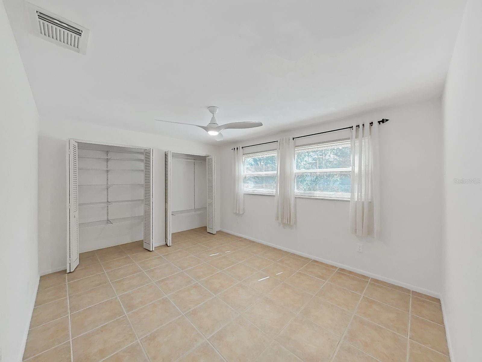 Bedroom 2 with dual closets & ceiling fan- Double Primary Suite.