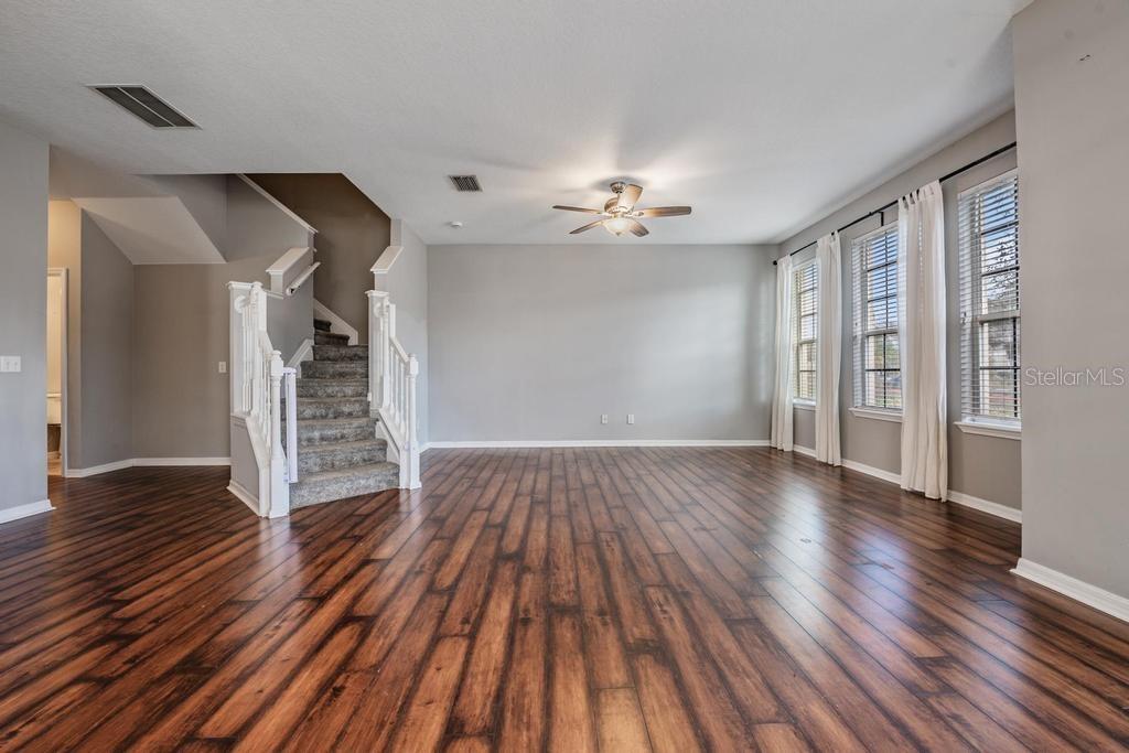 Dining Room/Living Room - lots of natural light and including blinds, drapes, fan and light fixture.