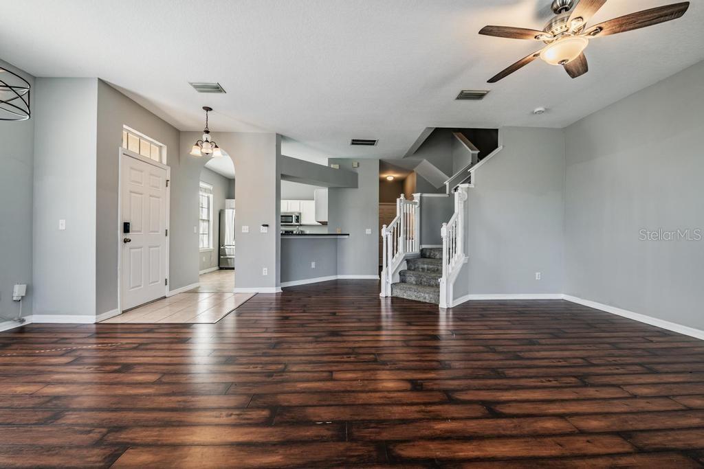 Dining Room/Living Room - lots of natural light and including blinds, drapes, fan and light fixture.