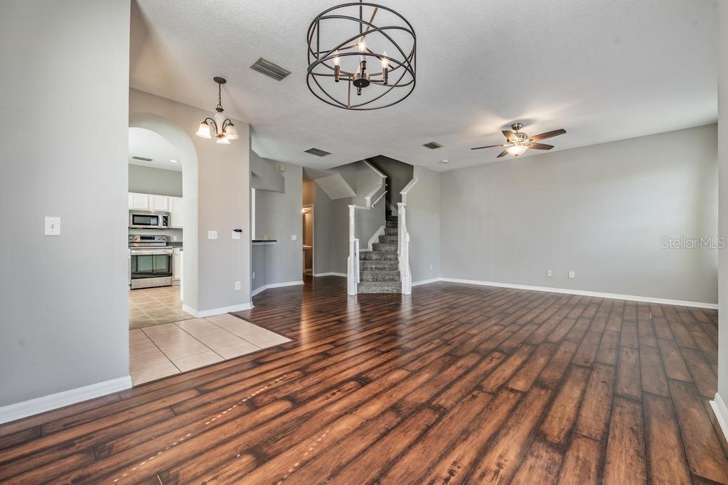 Dining Room/Living Room - lots of natural light and including blinds, drapes, fan and light fixture.