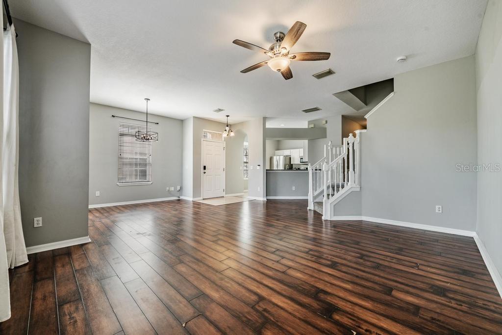 Dining Room/Living Room - lots of natural light and including blinds, drapes, fan and light fixture.