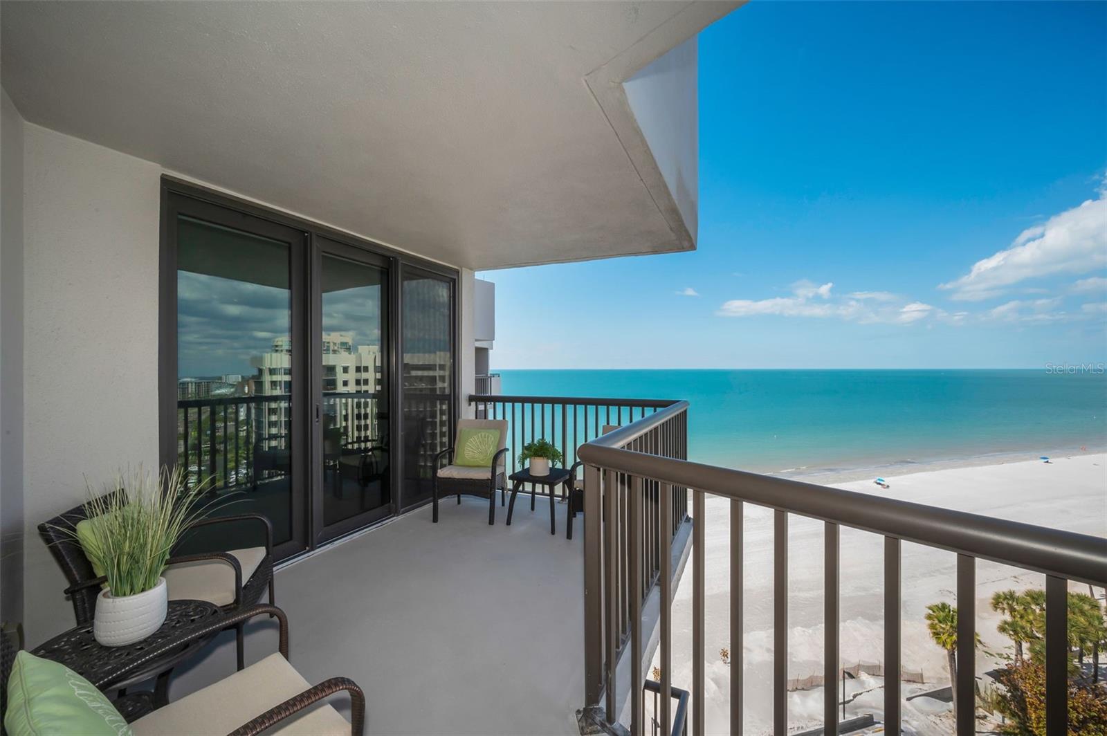 Step through the sliding glass doors onto the living room side of the wraparound balcony
