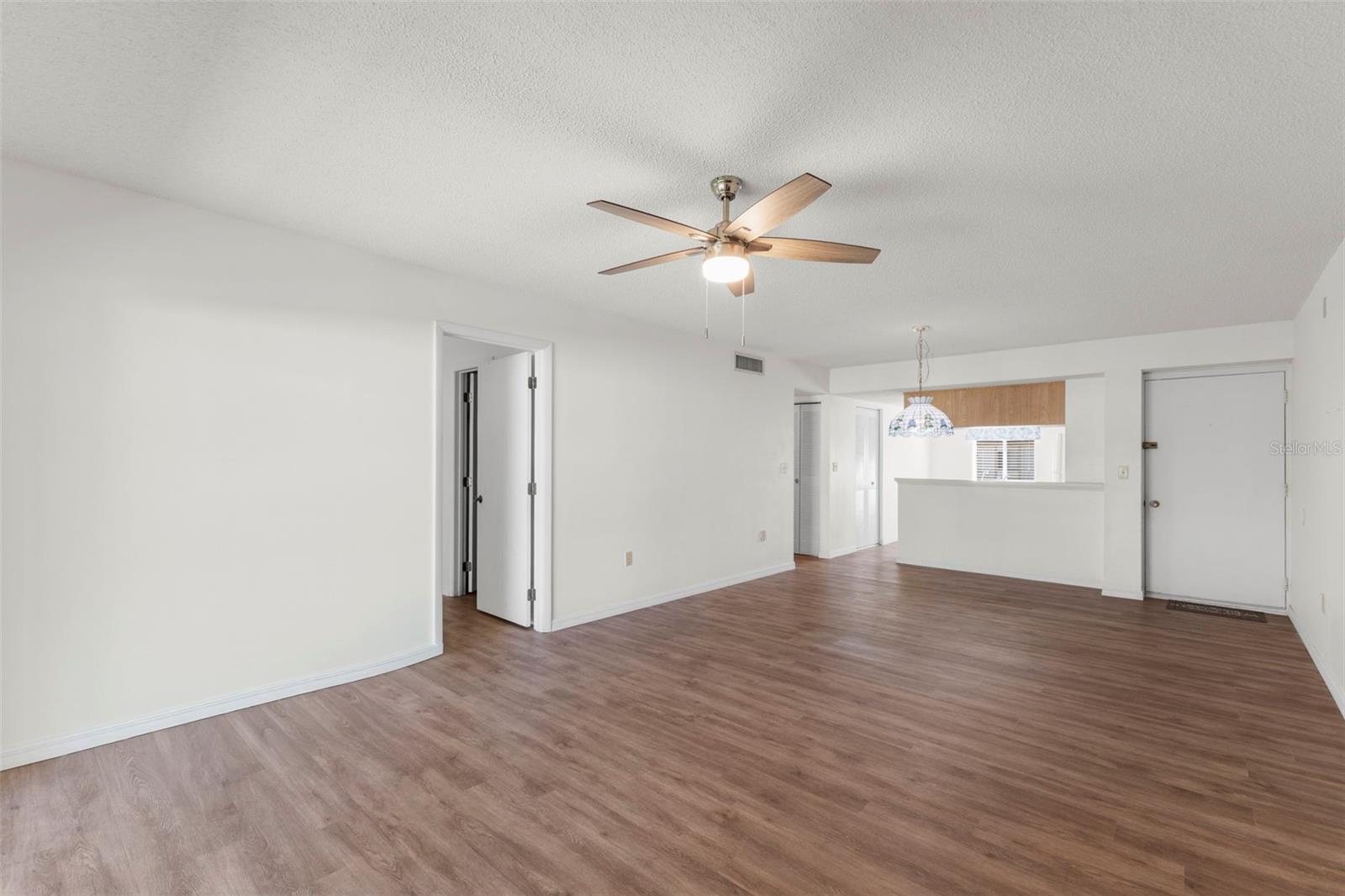 OPEN LIVING AND DINING AREA / NEAR KITCHEN IS THE SHORT HALLWAY TO 2ND BEDROOM AND BATHROOM