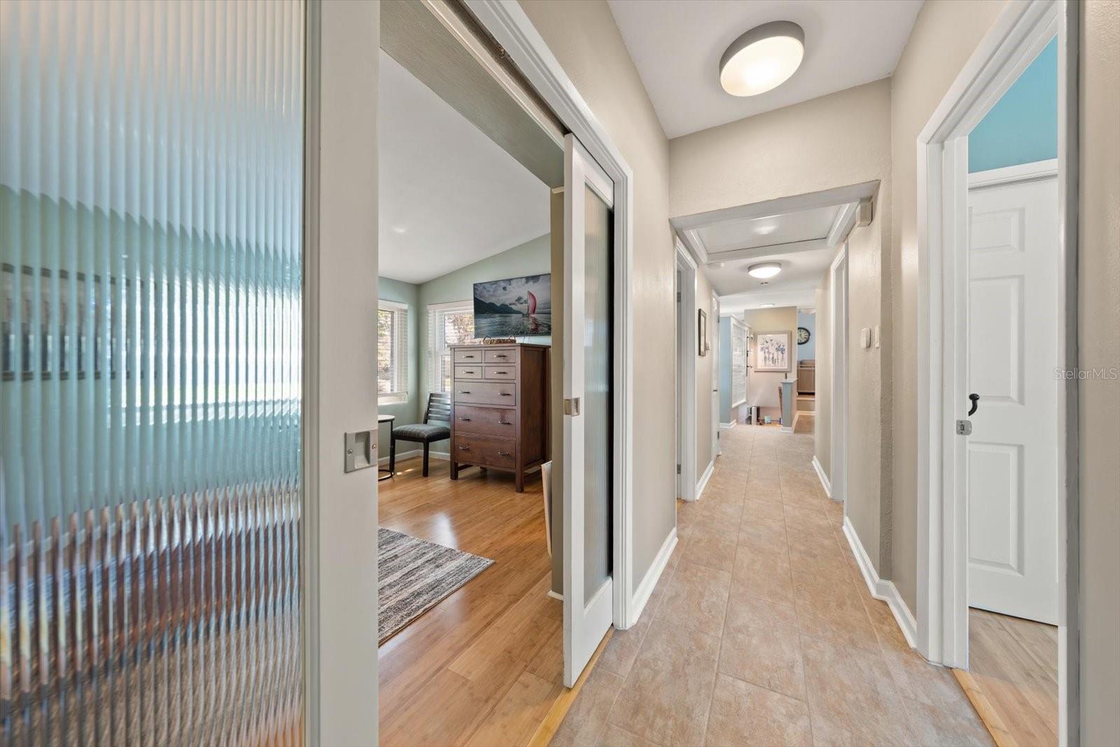 Hallway access to third bedroom presently used as a den. Beautiful wave glass pocket doors.