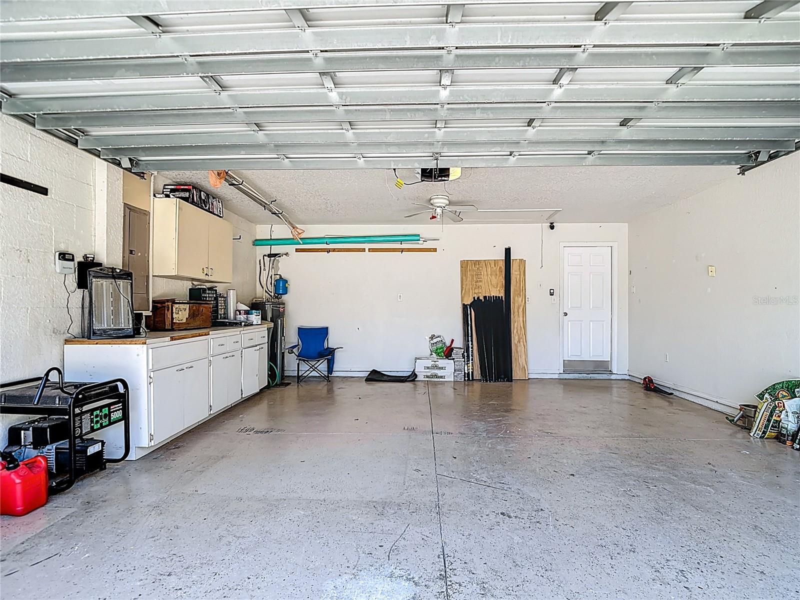 Garage with pull down stairs with some flooring