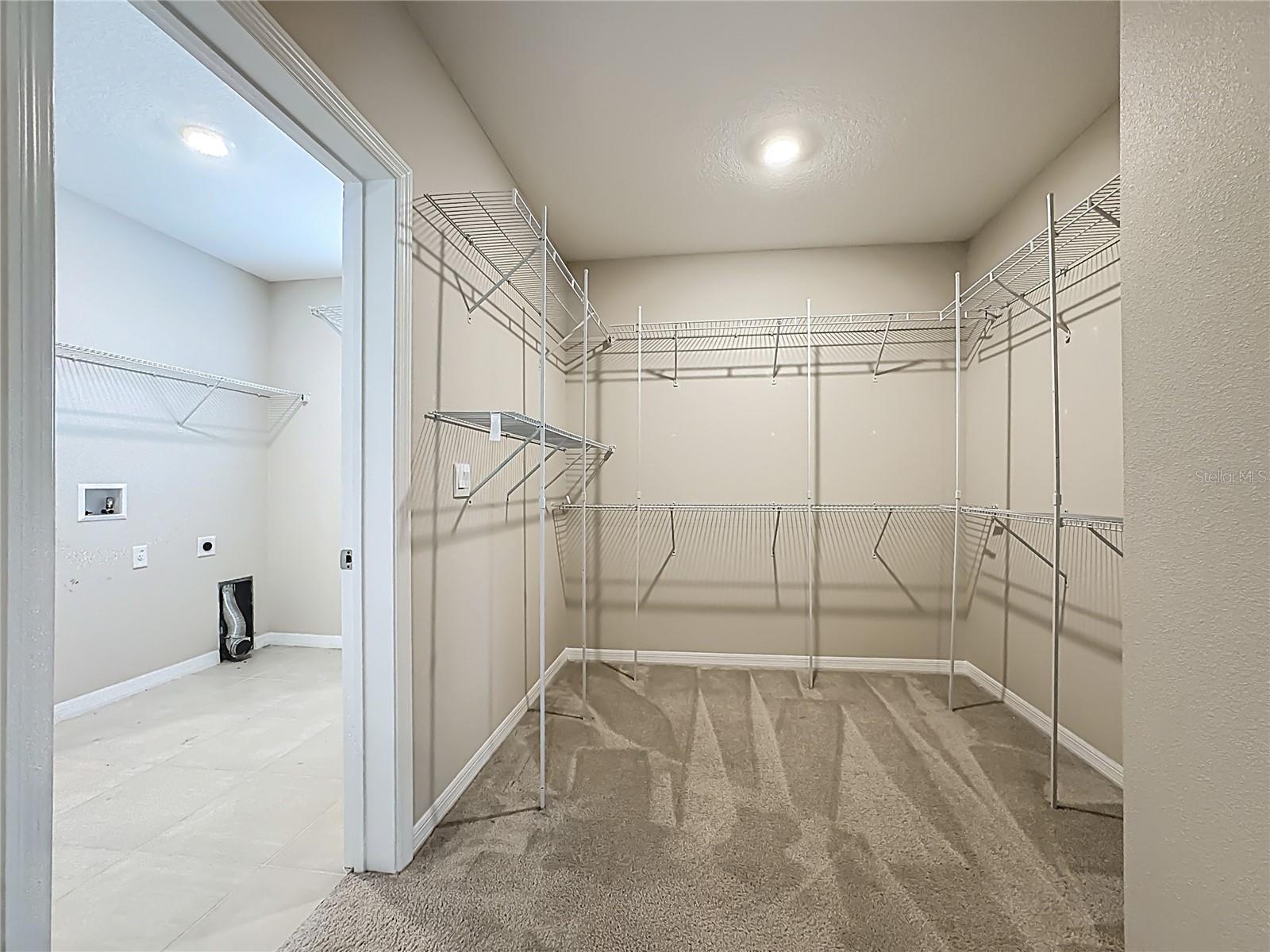 Primary Bedroom Walk-In-Closet Looking into Laundry Room