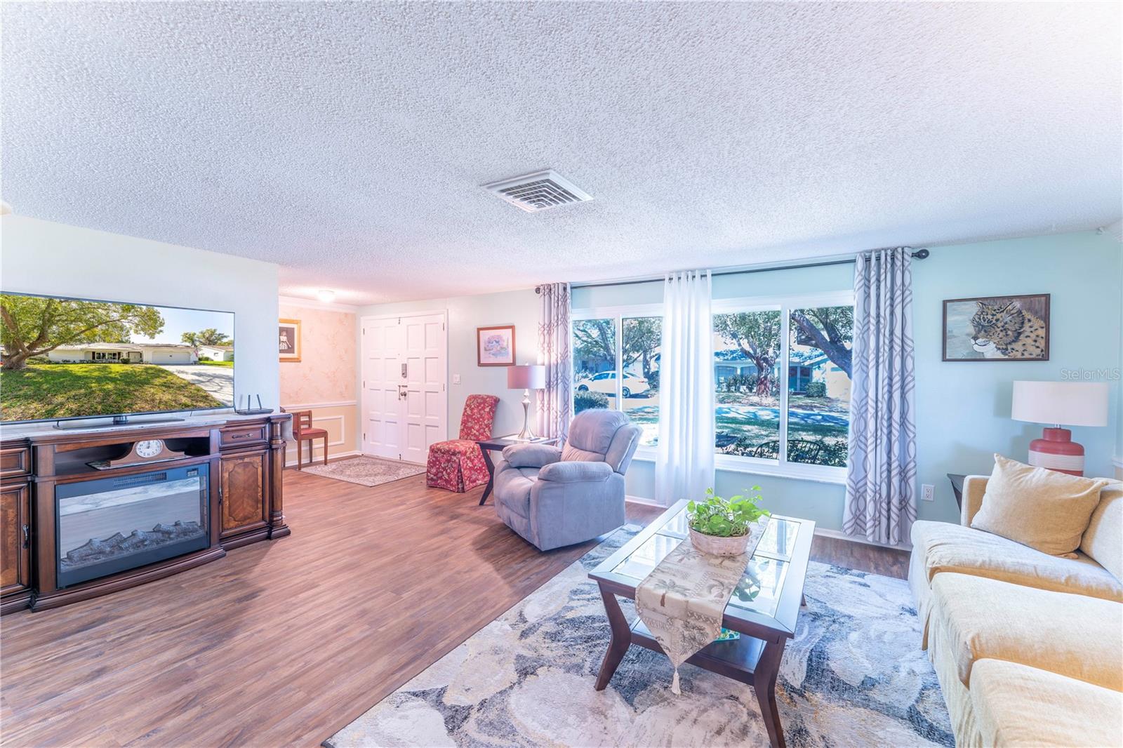 Bright and spacious living room featuring abundant natural light, durable flooring, and an easy flow for everyday living and entertaining.