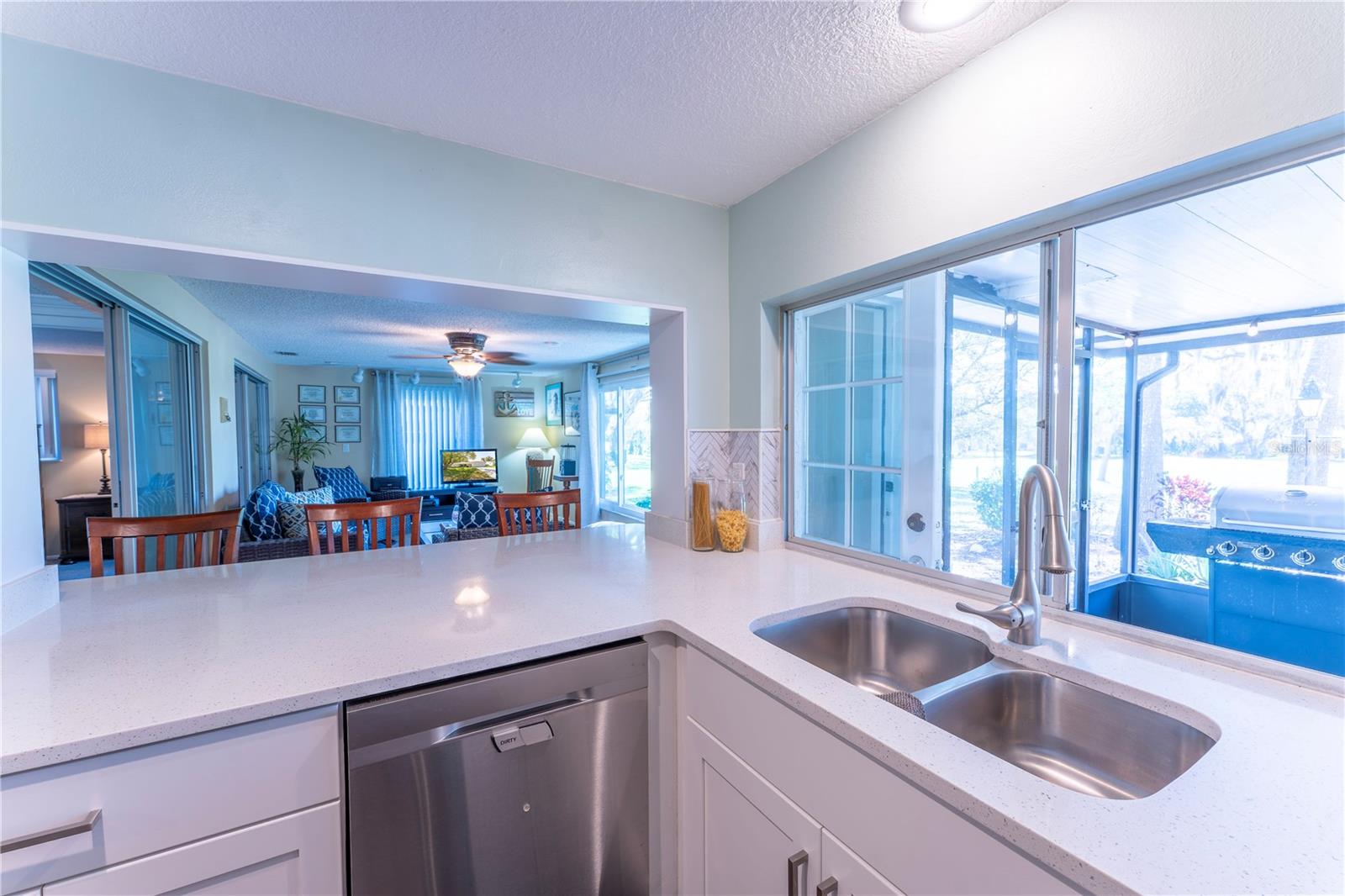 The newly remodeled kitchen the heart of the home, showcasing shaker cabinetry, Corian countertops, and an extended layout that opens seamlessly into the family room-perfect for entertaining.