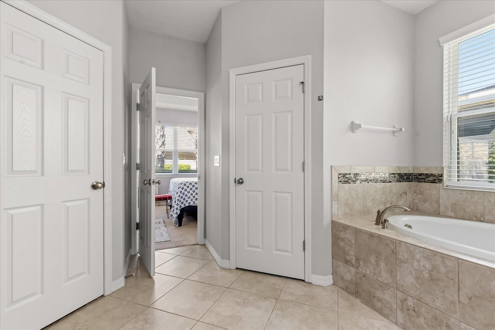 Primary bedroom bathroom with two walk-in closets