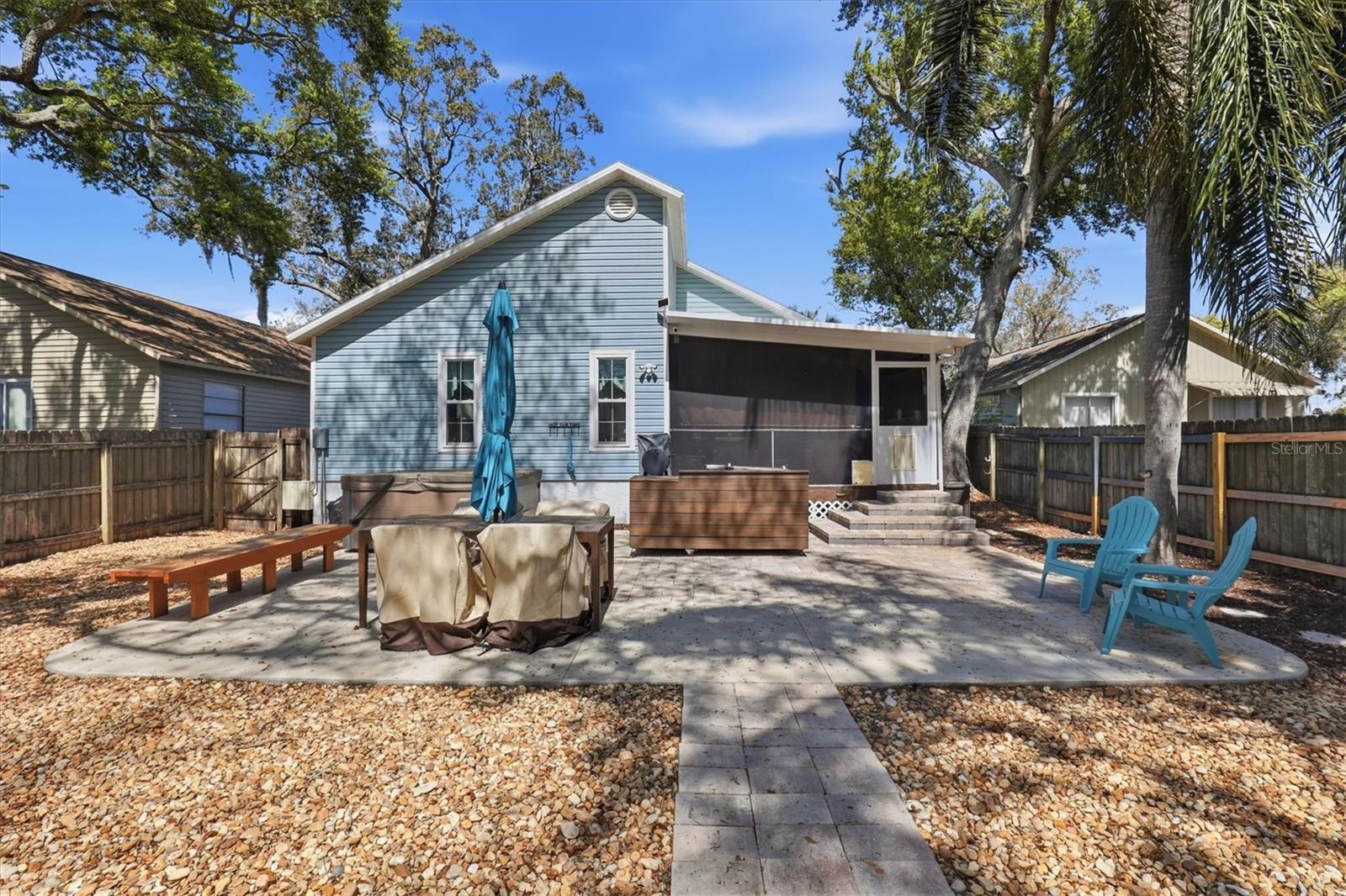 Private backyard with a large patio, built-in hot tub and grill, offering plenty of seating and space for outdoor entertaining.
