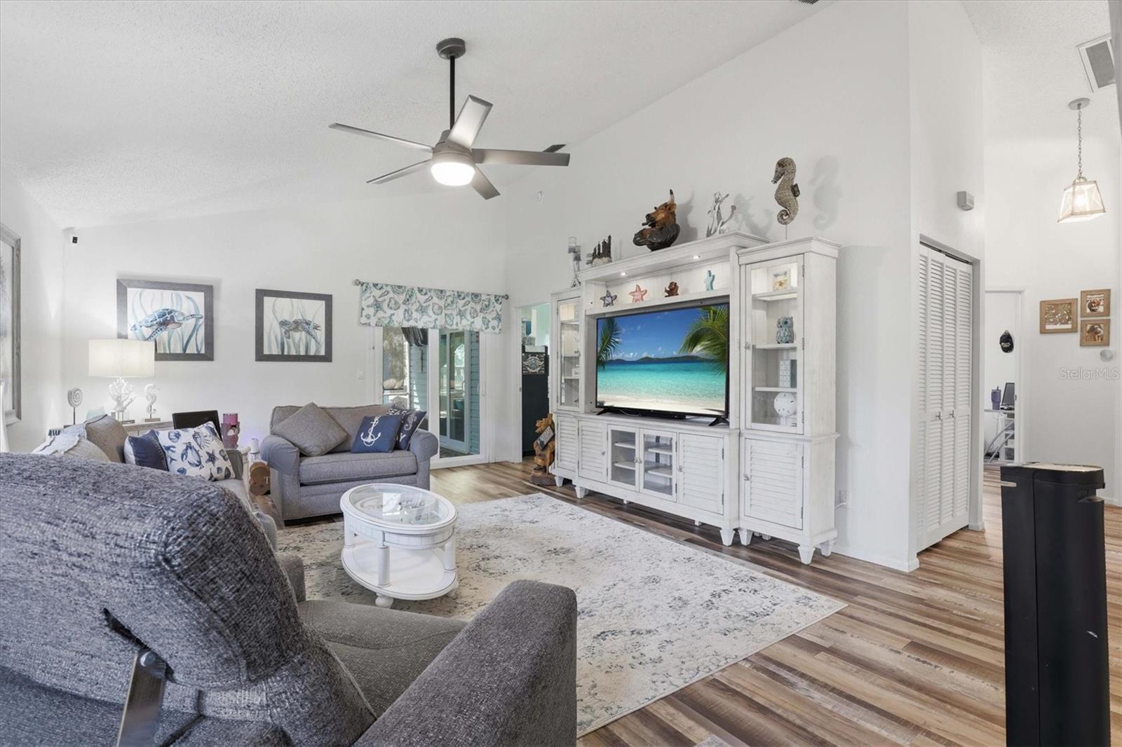 Vaulted ceilings enhance the open feel of this living room, complete with new hurricane-rated sliders leading to a private covered and screened porch.