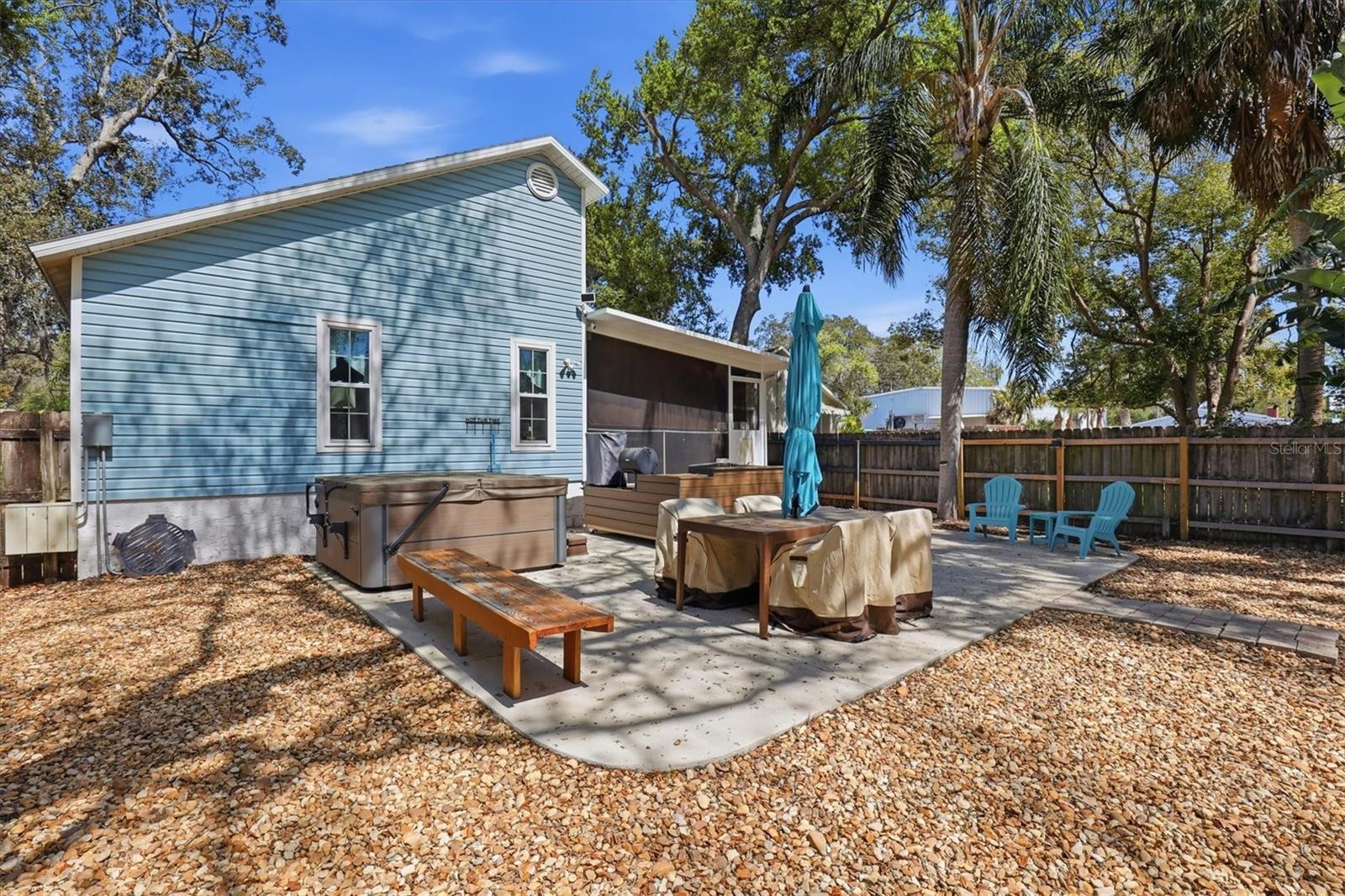 Spacious backyard patio with built-in hot tub, grill area, and plenty of seating for entertaining.
