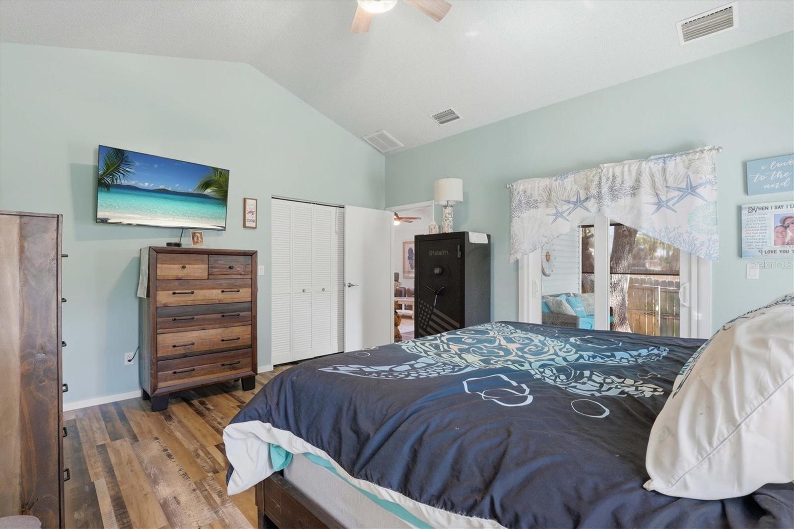 Bright primary bedroom with en suite bathroom, dual walk-in closets, and sliders that open to the screened back porch—perfect for morning coffee or relaxing evenings.
