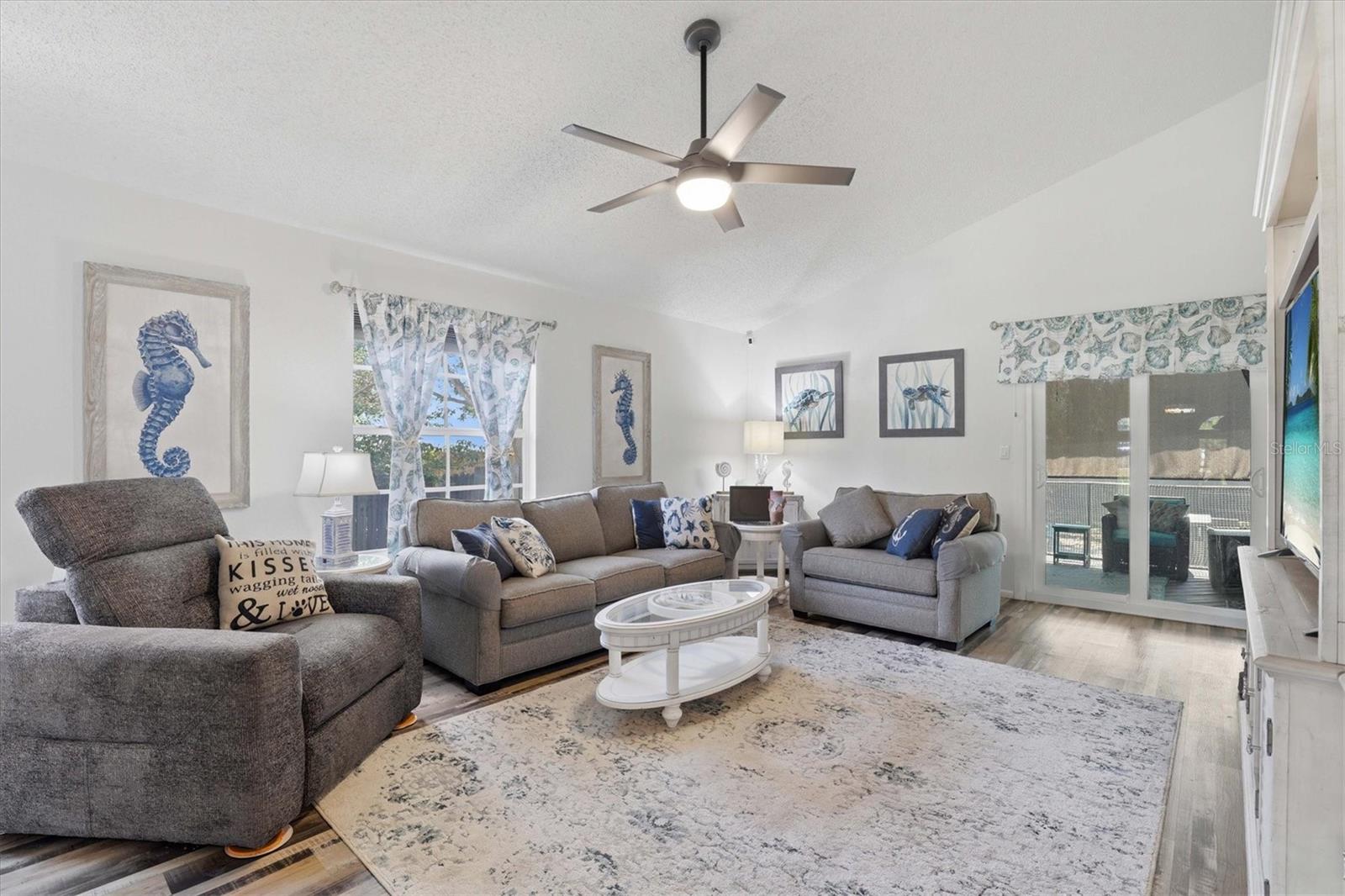 Open living room featuring vaulted ceilings and generous natural light, offering a comfortable space that flows easily into the rest of the home.