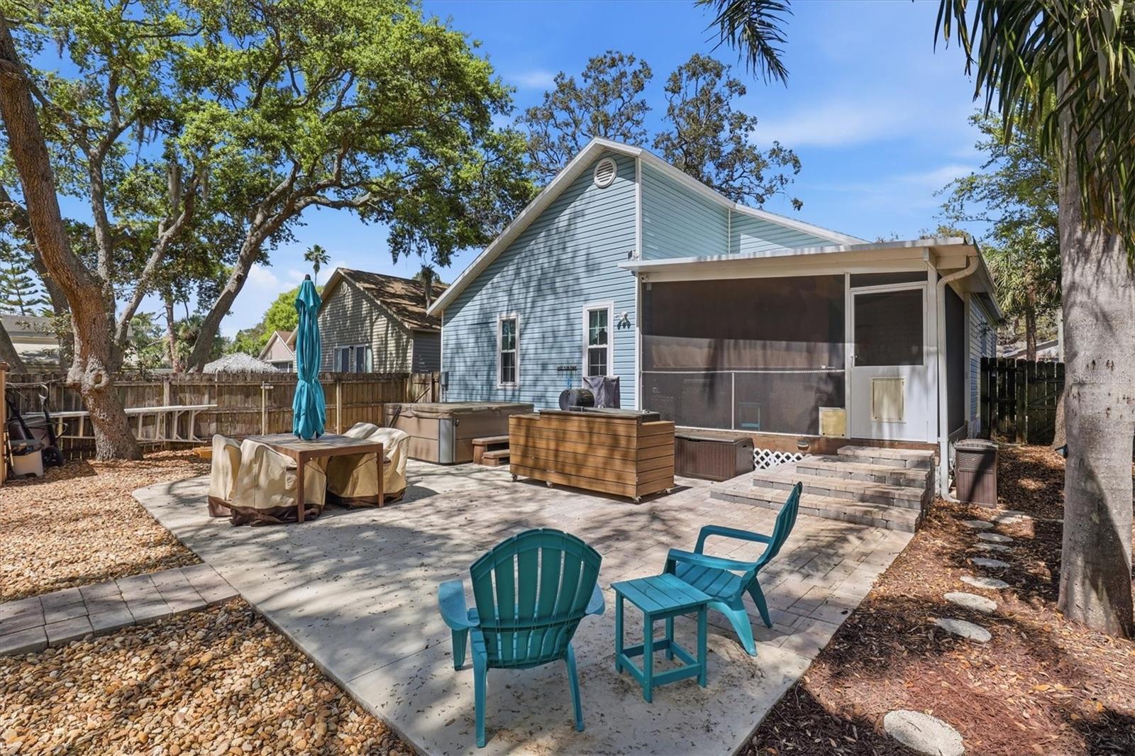 Large backyard patio featuring a hot tub, built-in grill, and ample space for outdoor gatherings.
